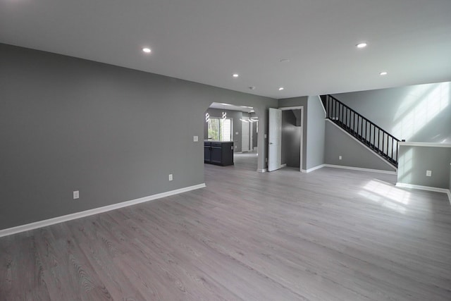 302 Leaf St, Tobyhanna, PA 18466 - unfurnished living room featuring arched walkways, light wood-style floors, stairway, and recessed lighting