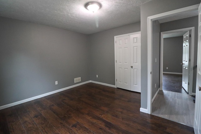 302 Leaf St, Tobyhanna, PA 18466 - unfurnished bedroom featuring dark wood-style flooring, a textured ceiling, and a closet