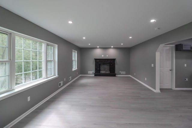 302 Leaf St, Tobyhanna, PA 18466 - unfurnished living room featuring wood finished floors, a stone fireplace, recessed lighting, and arched walkways