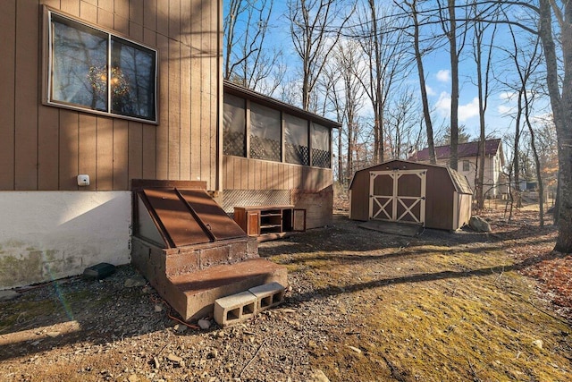 exterior space with a storage shed, an outbuilding, and a sunroom