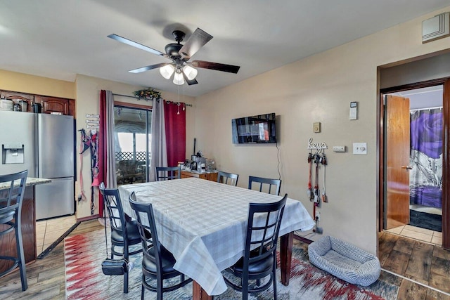 dining space with light wood-type flooring and a ceiling fan