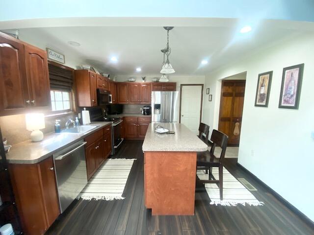 5132 Pocono Park Ln, Swiftwater, PA 18370 - kitchen with appliances with stainless steel finishes, dark wood-style flooring, a kitchen bar, light countertops, and recessed lighting