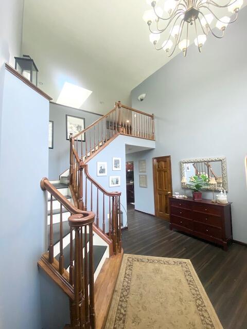 5132 Pocono Park Ln, Swiftwater, PA 18370 - staircase with wood finished floors, a chandelier, a skylight, and a towering ceiling