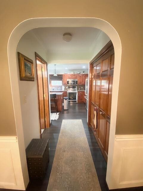 5132 Pocono Park Ln, Swiftwater, PA 18370 - hall featuring arched walkways, a wainscoted wall, dark wood-style floors, and a decorative wall