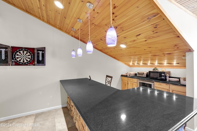 kitchen with black microwave, beverage cooler, baseboards, light brown cabinetry, and dark countertops