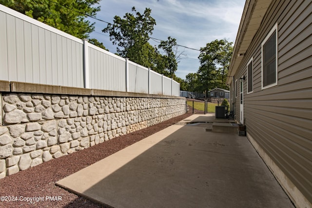 view of property exterior featuring a patio area, fence, and central AC