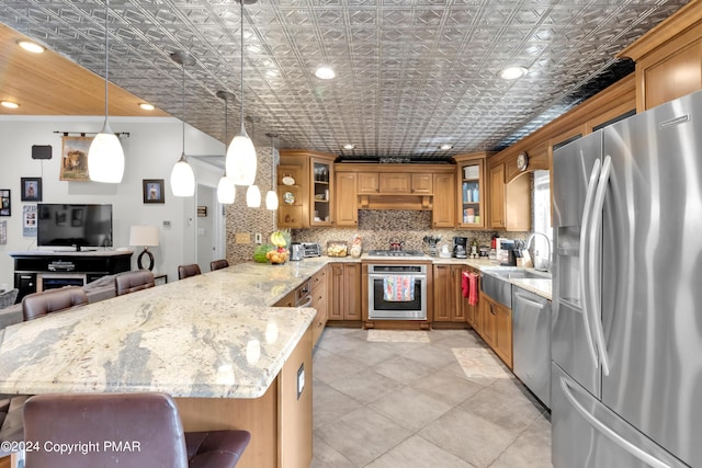 kitchen with an ornate ceiling, appliances with stainless steel finishes, glass insert cabinets, a peninsula, and backsplash