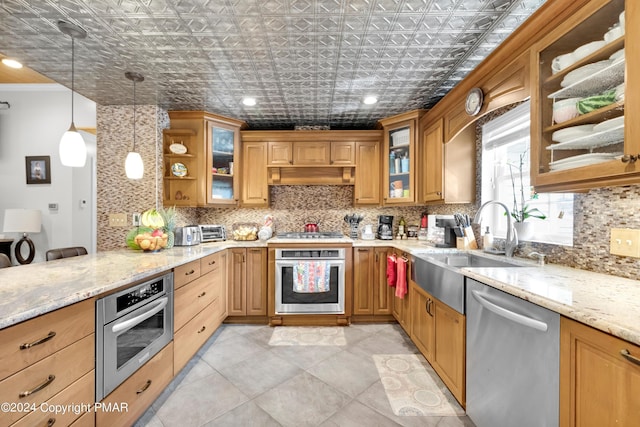 kitchen featuring an ornate ceiling, appliances with stainless steel finishes, decorative backsplash, and light stone counters