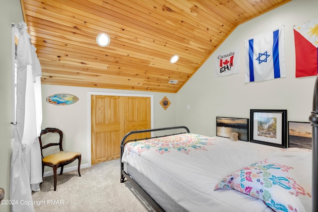 carpeted bedroom with a closet, visible vents, vaulted ceiling, wooden ceiling, and baseboards