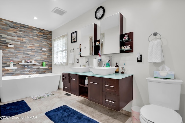 bathroom with toilet, visible vents, a freestanding bath, and vanity