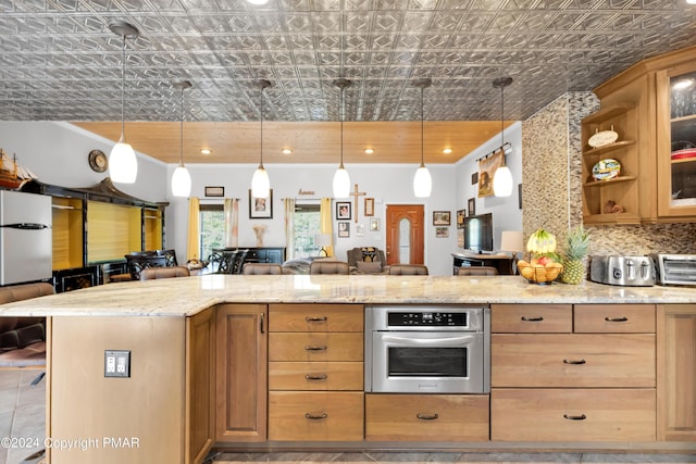 kitchen with light stone counters, stainless steel oven, a kitchen breakfast bar, open floor plan, and an ornate ceiling