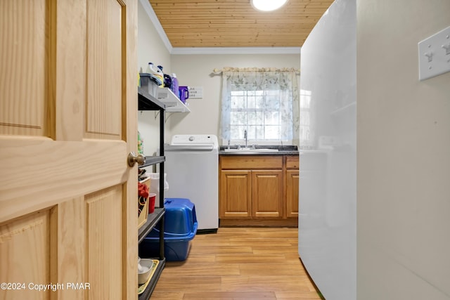 laundry room with laundry area, washer / clothes dryer, crown molding, light wood-type flooring, and a sink