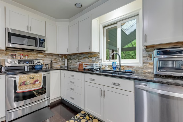 106 Legends Ct, East Stroudsburg, PA 18302 - kitchen with stainless steel appliances, dark stone countertops, white cabinets, and tasteful backsplash