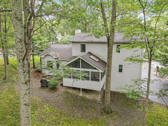 106 Legends Ct, East Stroudsburg, PA 18302 - back of property with a sunroom, roof with shingles, and a chimney