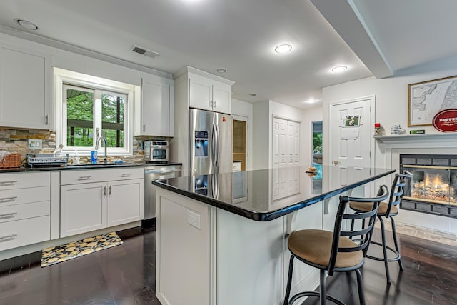 106 Legends Ct, East Stroudsburg, PA 18302 - kitchen with appliances with stainless steel finishes, dark countertops, a breakfast bar, white cabinets, and tasteful backsplash