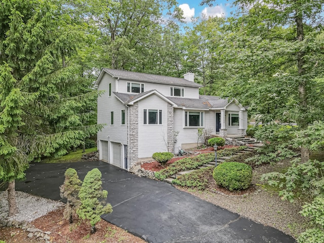 106 Legends Ct, East Stroudsburg, PA 18302 - view of front of house featuring a chimney, an attached garage, roof with shingles, and asphalt driveway