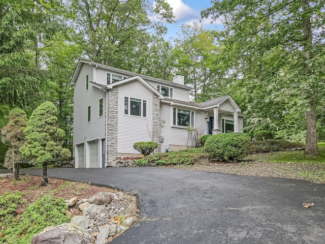 106 Legends Ct, East Stroudsburg, PA 18302 - view of front facade featuring a garage, a chimney, driveway, and a porch