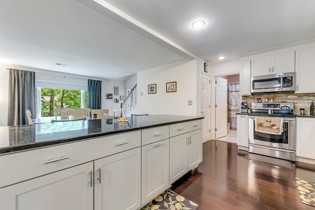 106 Legends Ct, East Stroudsburg, PA 18302 - kitchen with stainless steel appliances, dark wood-style flooring, white cabinetry, backsplash, and dark stone countertops