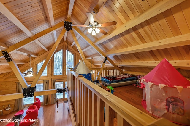 interior space with lofted ceiling with beams, wood walls, wood finished floors, and wood ceiling