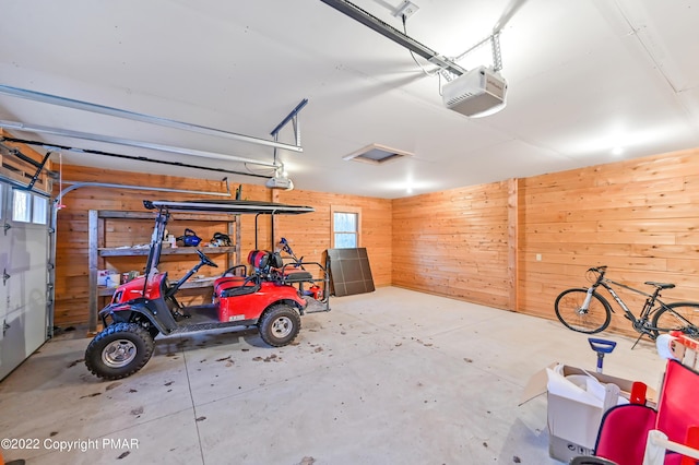 garage with wooden walls and a garage door opener