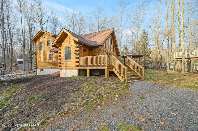 view of home's exterior with a deck and log siding