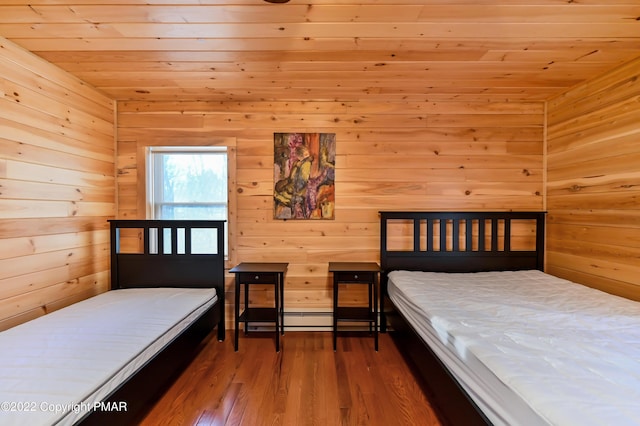 bedroom featuring wood walls, wood ceiling, a baseboard heating unit, and wood finished floors