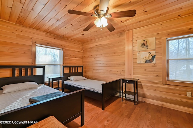 bedroom with wooden ceiling, wood walls, and wood finished floors