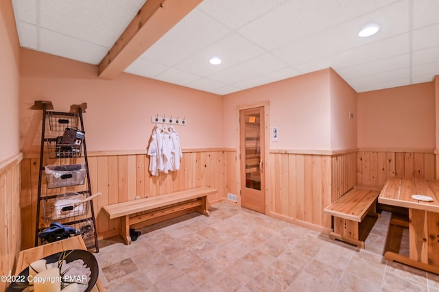 mudroom with a wainscoted wall, recessed lighting, a drop ceiling, and wood walls