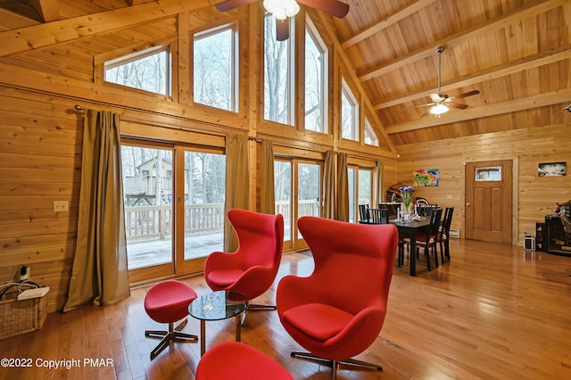 living area with a healthy amount of sunlight, wood-type flooring, wood ceiling, and wooden walls