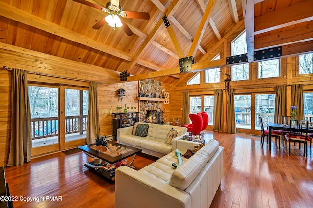 living room with wooden ceiling, hardwood / wood-style flooring, wooden walls, and beamed ceiling