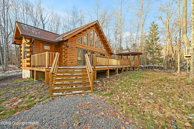 exterior space featuring a deck, stairway, and log siding