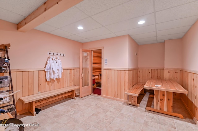 mudroom with a wainscoted wall, wooden walls, a drop ceiling, and recessed lighting