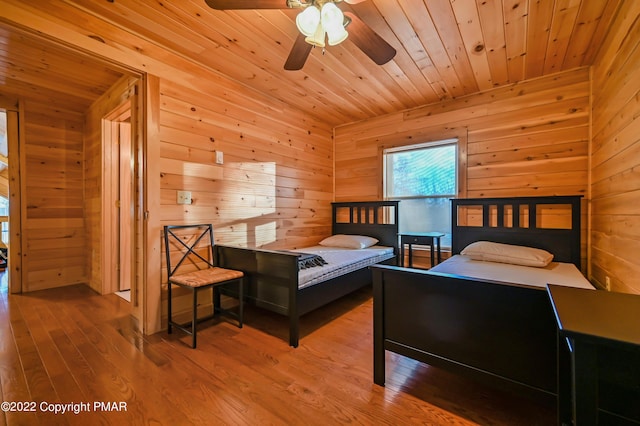 bedroom featuring wood finished floors, wood ceiling, and wooden walls