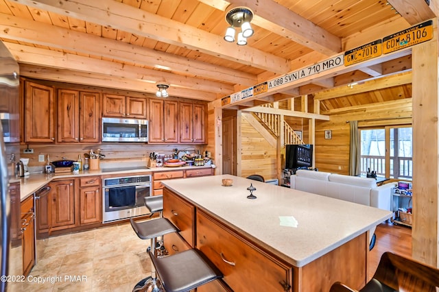 kitchen with wood walls, stainless steel appliances, and brown cabinetry