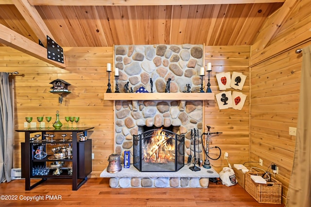 details with wooden ceiling, a stone fireplace, wood finished floors, and wood walls