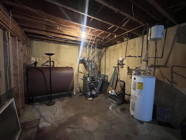 unfinished below grade area with a heating unit, electric water heater, and heating fuel