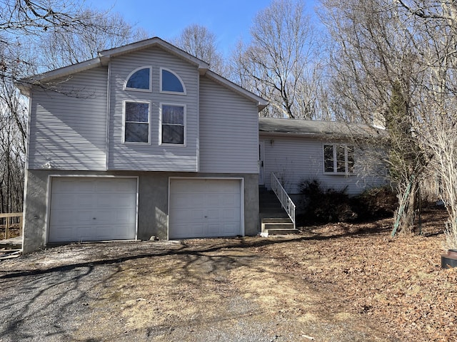 exterior space with a garage, dirt driveway, and stucco siding