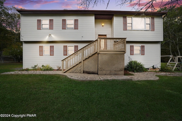 back of property with stairway and a yard