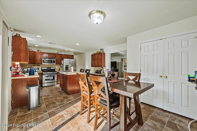 dining space with recessed lighting, stone finish flooring, and a toaster