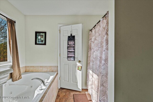 bathroom featuring a tub with jets and tile patterned floors