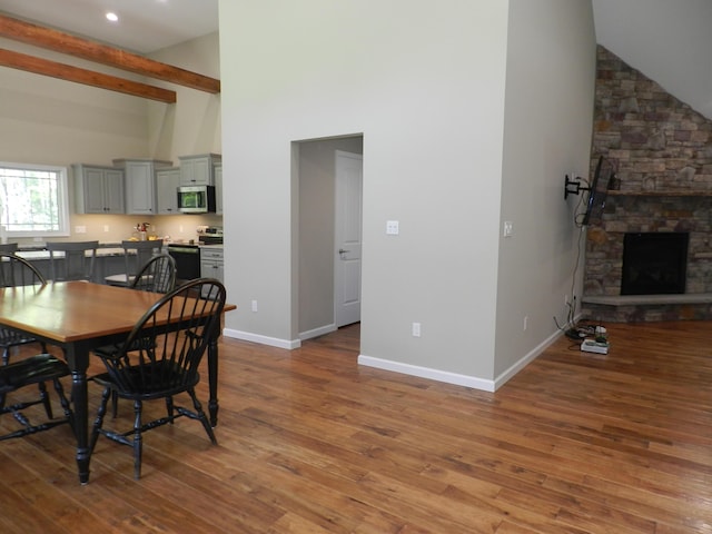 dining area featuring high vaulted ceiling, wood finished floors, baseboards, beam ceiling, and recessed lighting