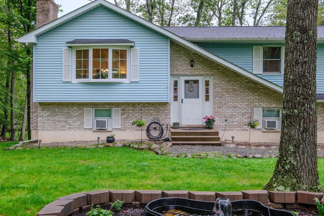 113 Larsen Ln, Cresco, PA 18326 - split foyer home featuring brick siding, a front lawn, a chimney, and cooling unit