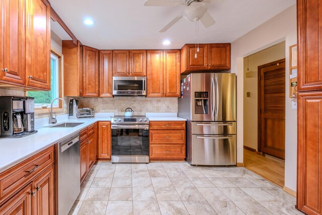 113 Larsen Ln, Cresco, PA 18326 - kitchen featuring appliances with stainless steel finishes, light countertops, ceiling fan, decorative backsplash, and brown cabinetry
