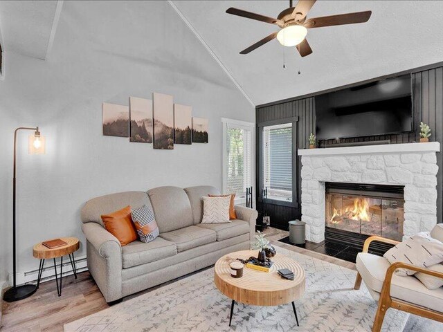 216 Snow Ridge Cir, Lake Harmony, PA 18624 - living area with wood finished floors, ceiling fan, a fireplace, a baseboard radiator, and high vaulted ceiling