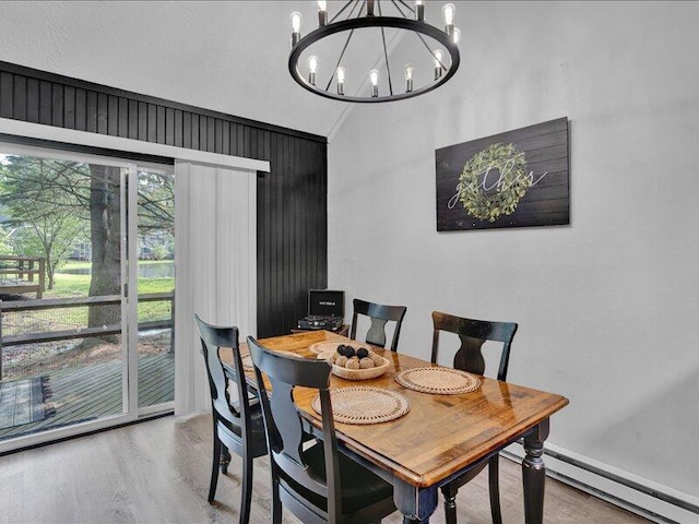 216 Snow Ridge Cir, Lake Harmony, PA 18624 - dining space with vaulted ceiling, baseboard heating, a chandelier, and wood finished floors