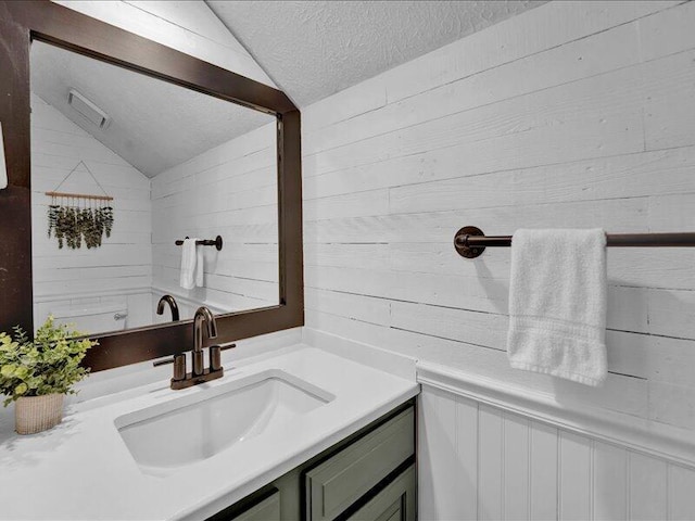 216 Snow Ridge Cir, Lake Harmony, PA 18624 - bathroom with lofted ceiling, vanity, wooden walls, and a textured ceiling