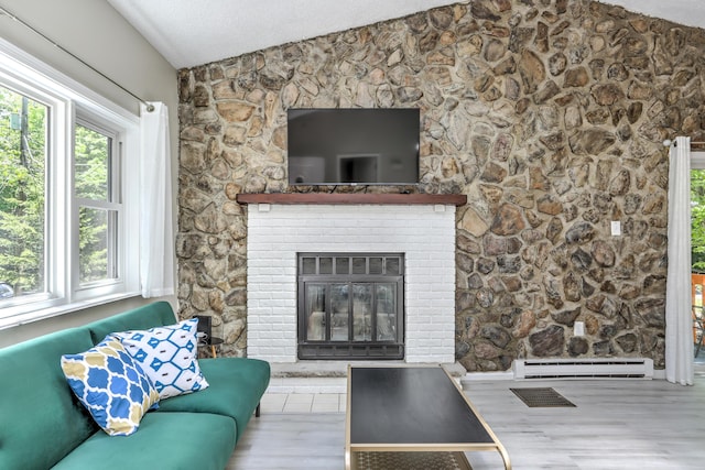 living room with visible vents, a glass covered fireplace, lofted ceiling, a textured ceiling, and a baseboard heating unit