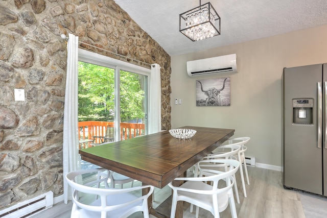 dining area with a baseboard heating unit, an AC wall unit, light wood-style flooring, and a textured ceiling