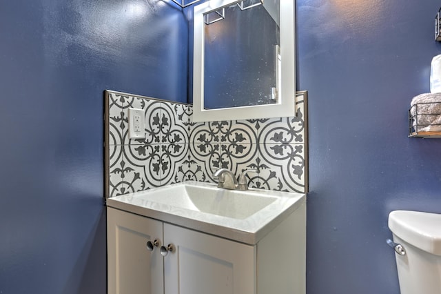 bathroom with toilet, tasteful backsplash, and vanity