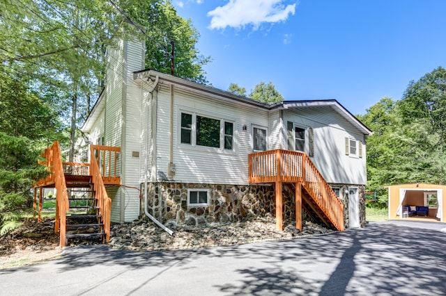 view of front of home with stairway, driveway, a chimney, and a garage